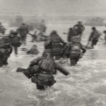 US Soldiers wade into shore at Omaha